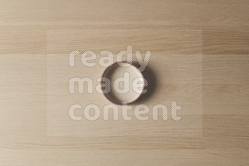 A beige pottery oven bowl on light wooden background