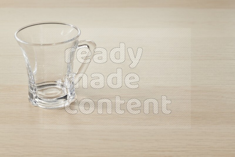 An empty glass cup on light wooden background