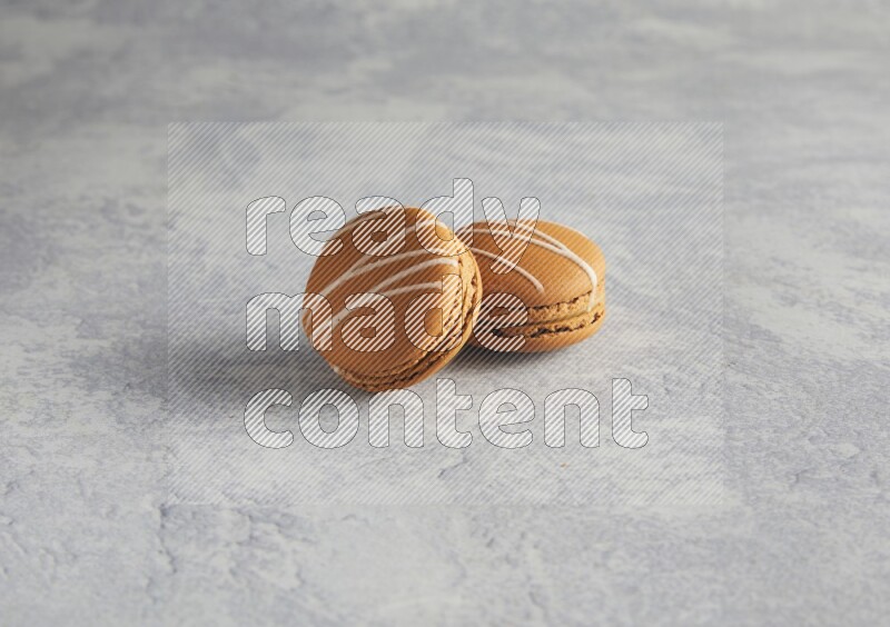 45º Shot of two Brown Irish Cream macarons  on white  marble background