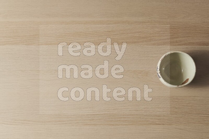 وعاء فخاري أبيض على خلفية خشبية فاتحة