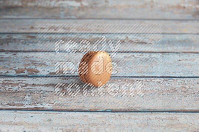 45º Shot of Brown Coffee macaron on light blue wooden background