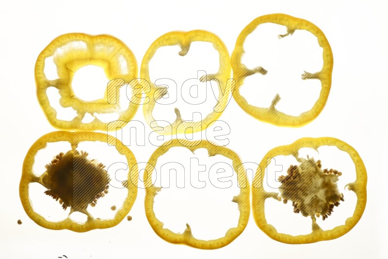 Yellow bell pepper slices on illuminated white background