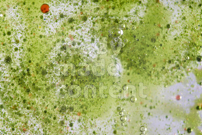 Close-ups of abstract red and green watercolor drops on oil Surface on green background