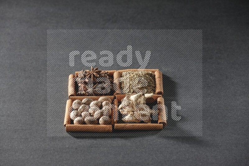 4 squares of cinnamon sticks full of star anise, cumin, dried ginger and nutmegs on black flooring