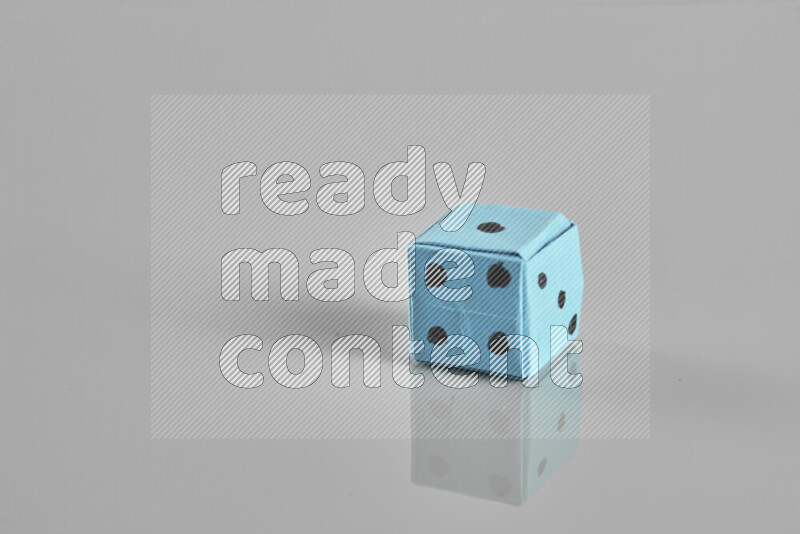 Origami dice on grey background