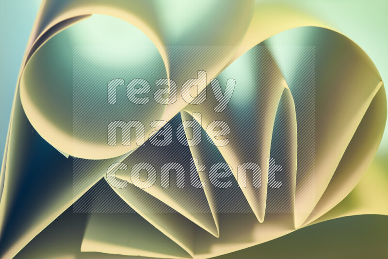 An artistic display of paper folds creating a harmonious blend of geometric shapes, highlighted by soft lighting in green and warm tones