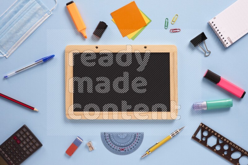 A blackboard with assorted school supplies on blue background