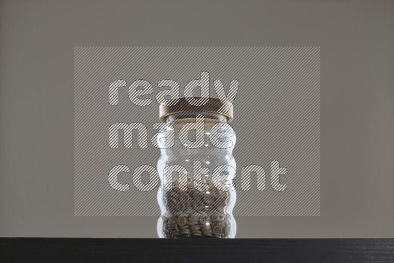 أزرار متنوعة في وعاء زجاجي علي خلفية سوداء