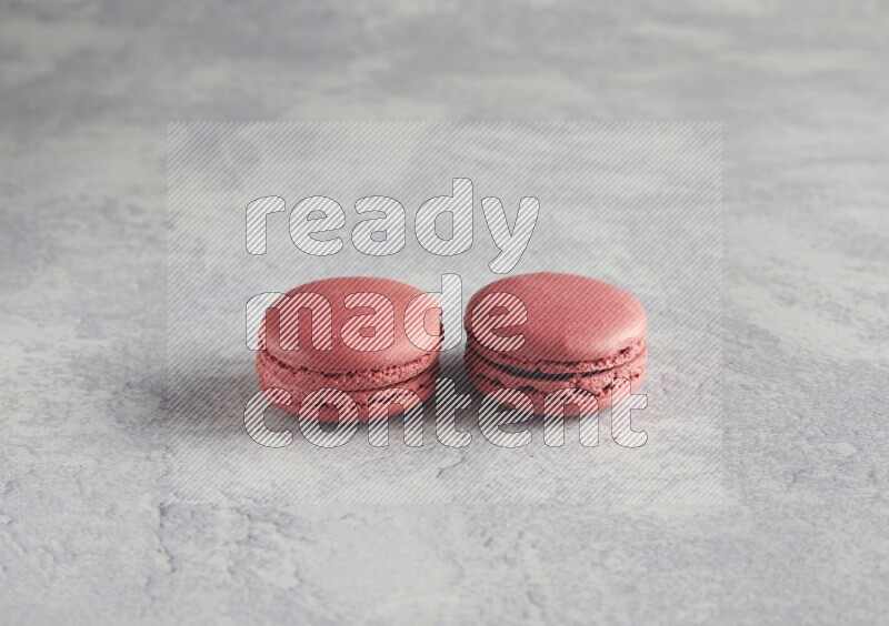 45º Shot of two Pink Raspberry macarons  on white  marble background