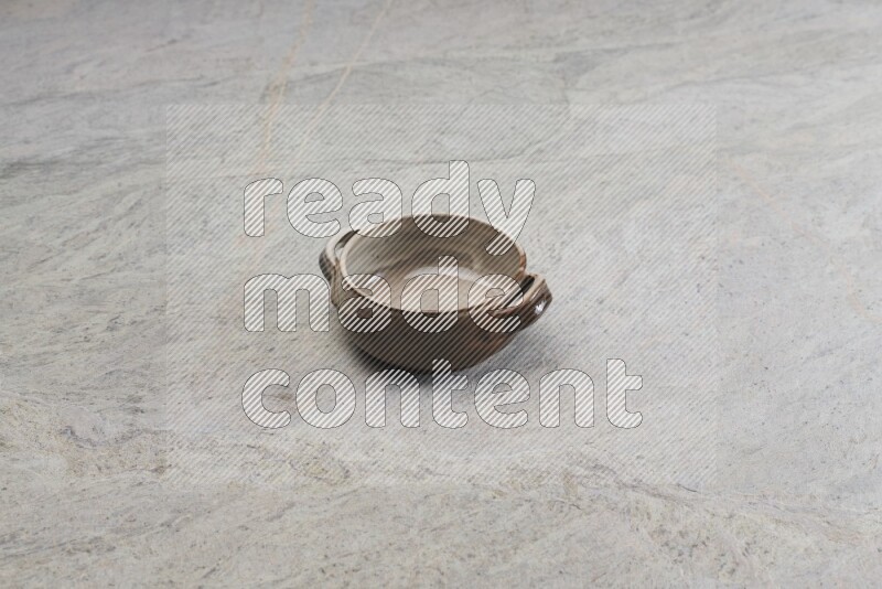 A multicolored pottery bowl on grey marble background