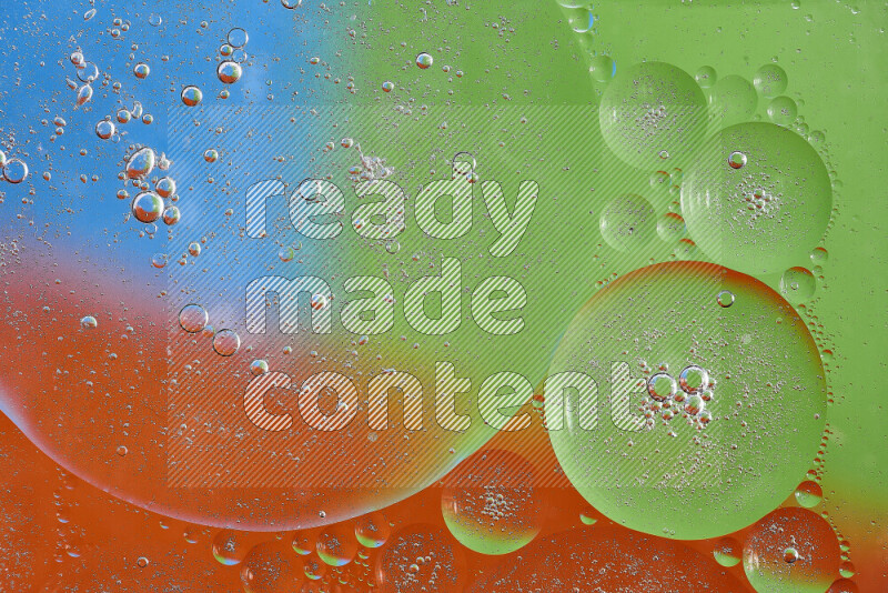 Close-ups of abstract oil bubbles on water surface in shades of orange, green and blue
