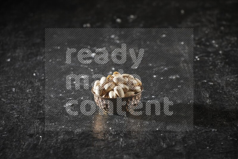Nuts in a metal bowl in a dark setup