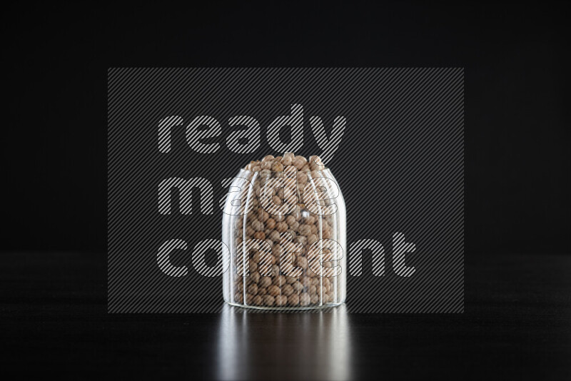Chickpeas in a glass jar on black background