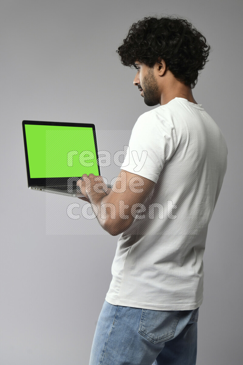 A man wearing casual standing and showing a laptop screen on white background