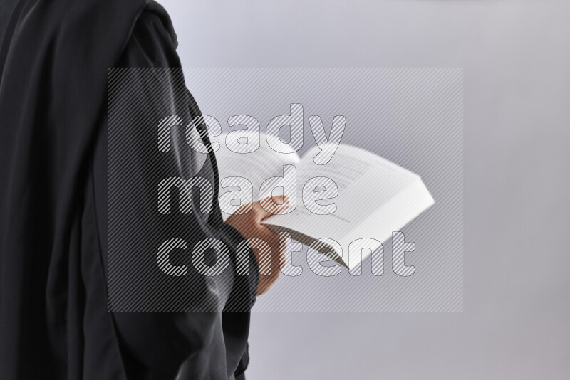 A woman in abaya holding books and a board in different positions (back to school)