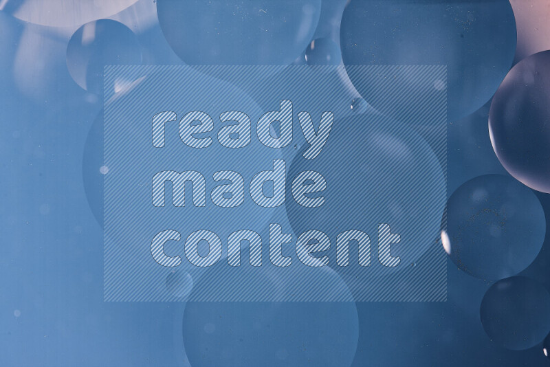 Close-ups of abstract oil bubbles on water surface in shades of blue