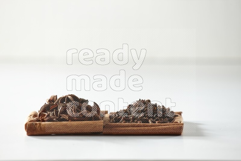 2 squares of cinnamon sticks full of cloves and star anise on white flooring