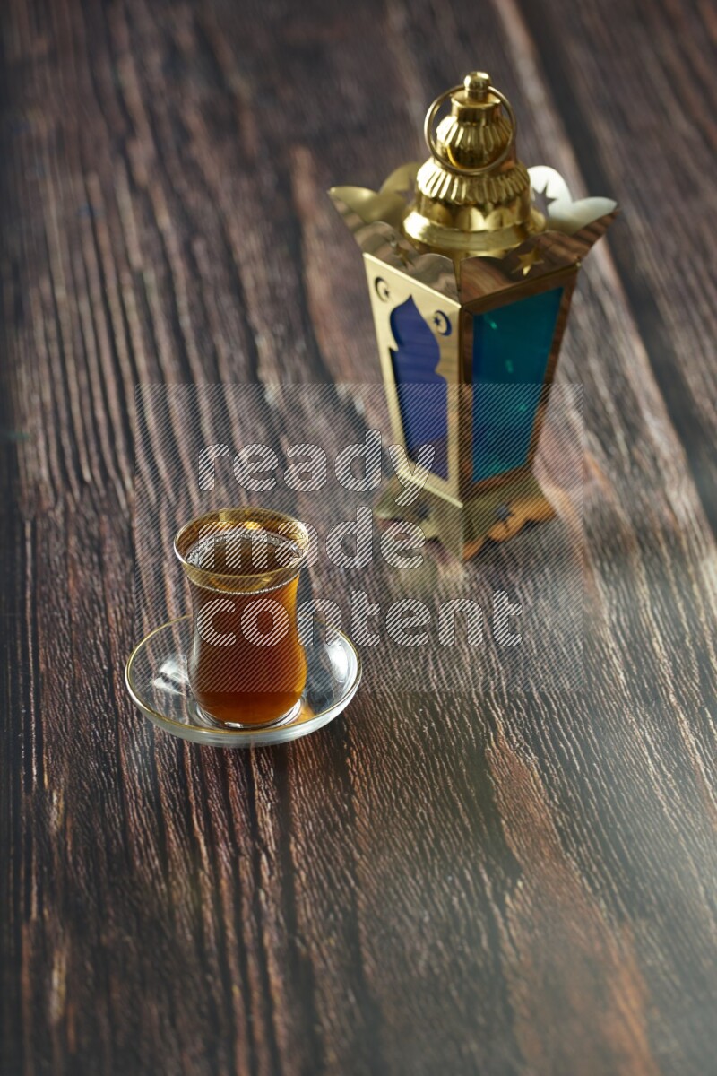 A golden lantern with different drinks, dates, nuts, prayer beads and quran on brown wooden background