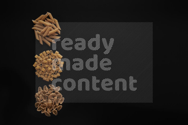 Different pasta types in 3 bunches on black background