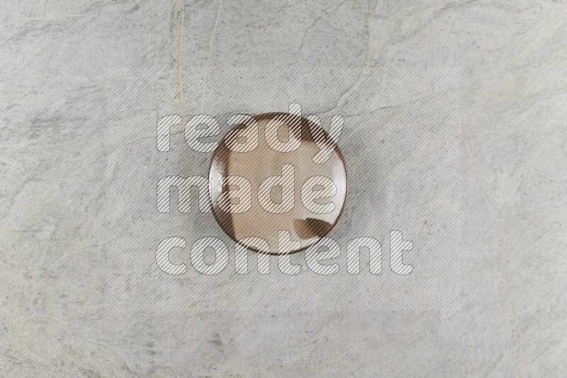 A multicolored pottery plate on grey marble background