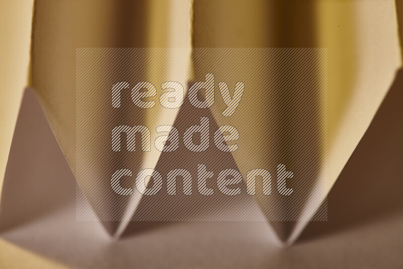 صورة مجردة مقربة تظهر طيات ورقية هندسية حادة بتدرجات اللون الأخضر مع درجات لونية دافئة