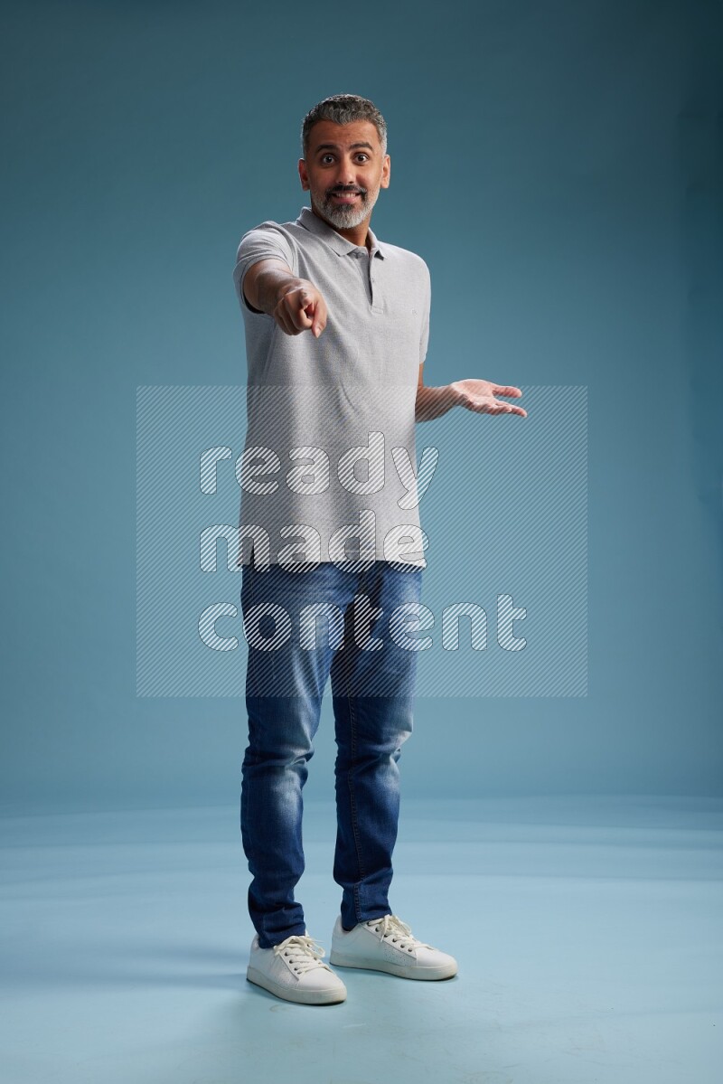 Man Standing Interacting with the camera on blue background