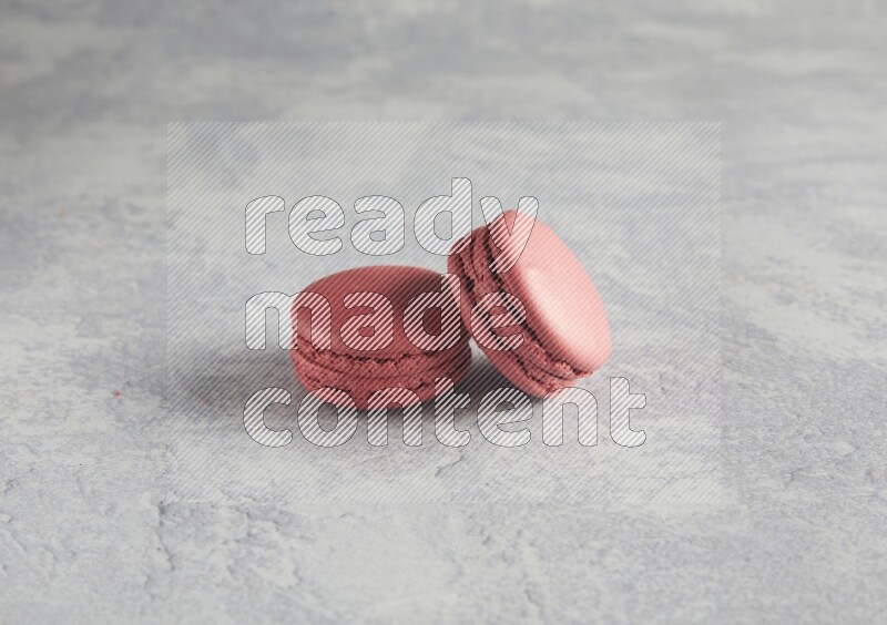 45º Shot of two Pink Raspberry macarons  on white  marble background