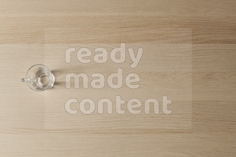 An empty glass cup on light wooden background