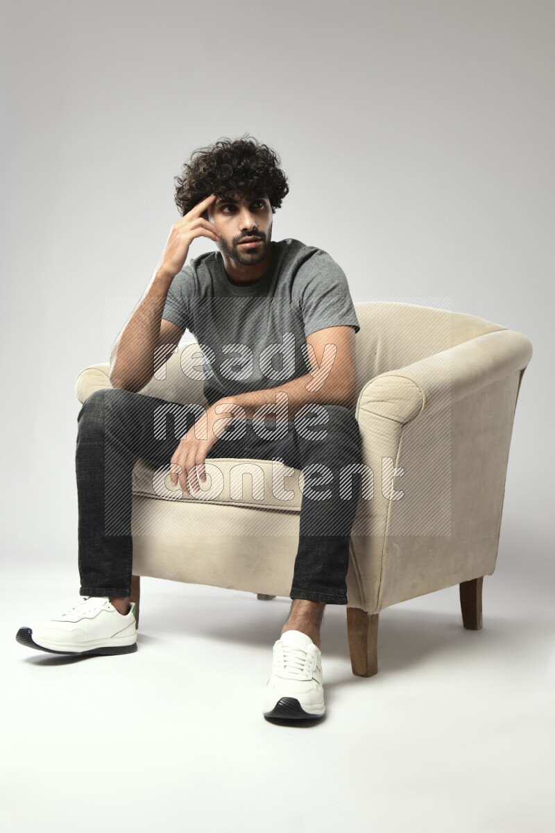 A man wearing casual sitting on a chair making a hand gesture on white background
