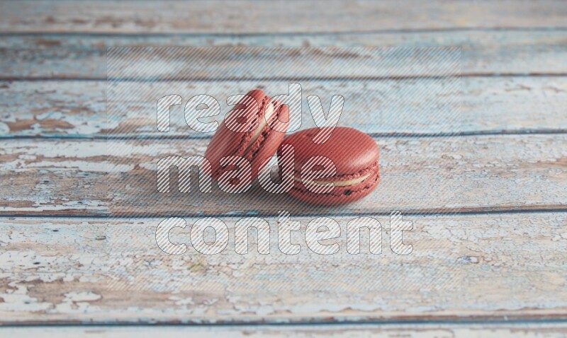 45º Shot of two Red Velvet macarons on light blue wooden background