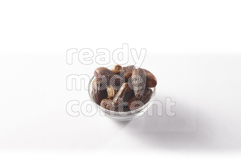 Dates in a glass bowl on white background