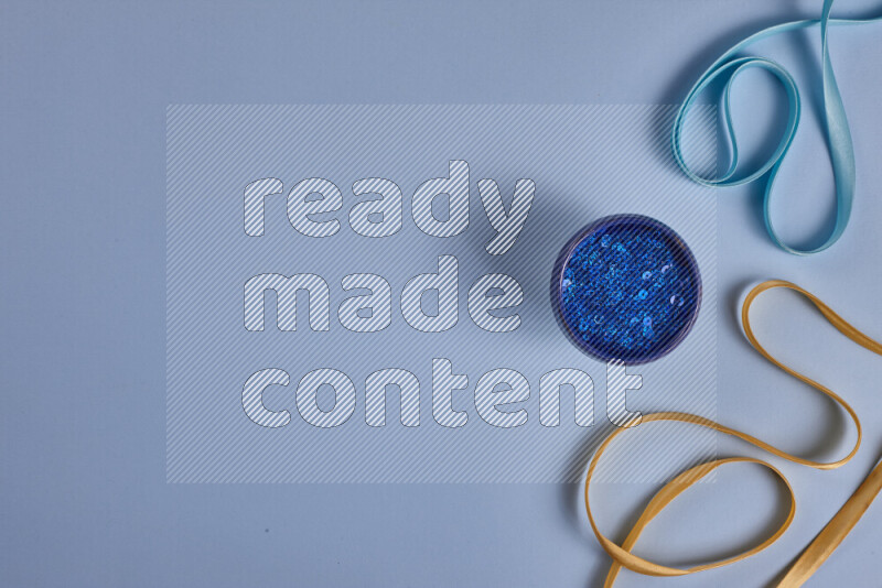 A yellow and blue collection of sewing and tailoring tools arranged on a blue background