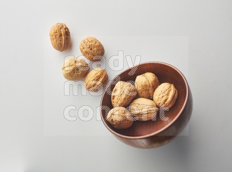 Top-view shot of walnut in a container on white background