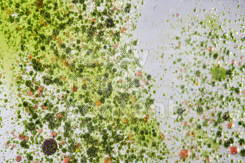 Close-ups of abstract green and red watercolor drops on oil Surface on white background