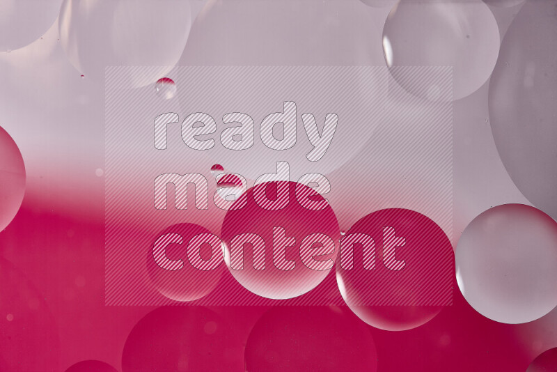 Close-ups of abstract oil bubbles on water surface in shades of white and pink