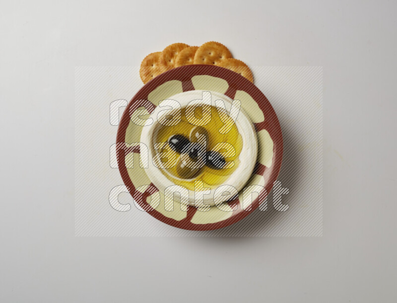 Lebnah garnished with olives in a traditional plate on a white background