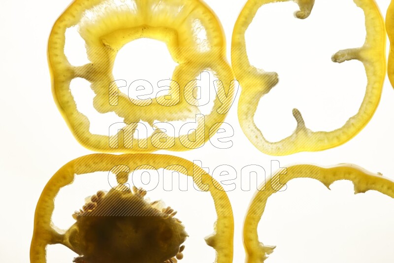 Yellow bell pepper slices on illuminated white background