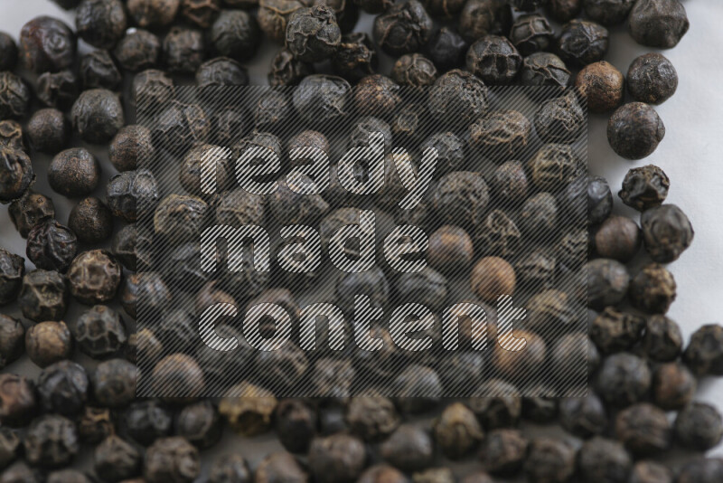 Black pepper beads on white background