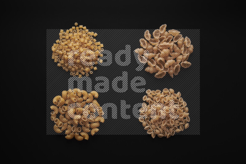 Different pasta types in bunches on black background