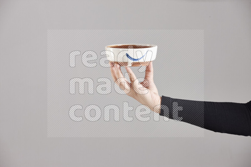 A woman in black abaya holding different pottery essentials in different positions