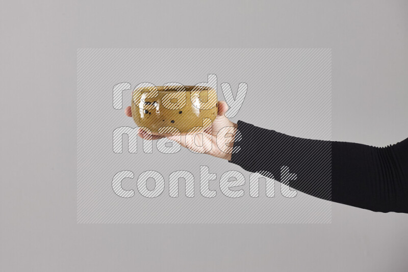 A woman in black abaya holding different pottery essentials in different positions