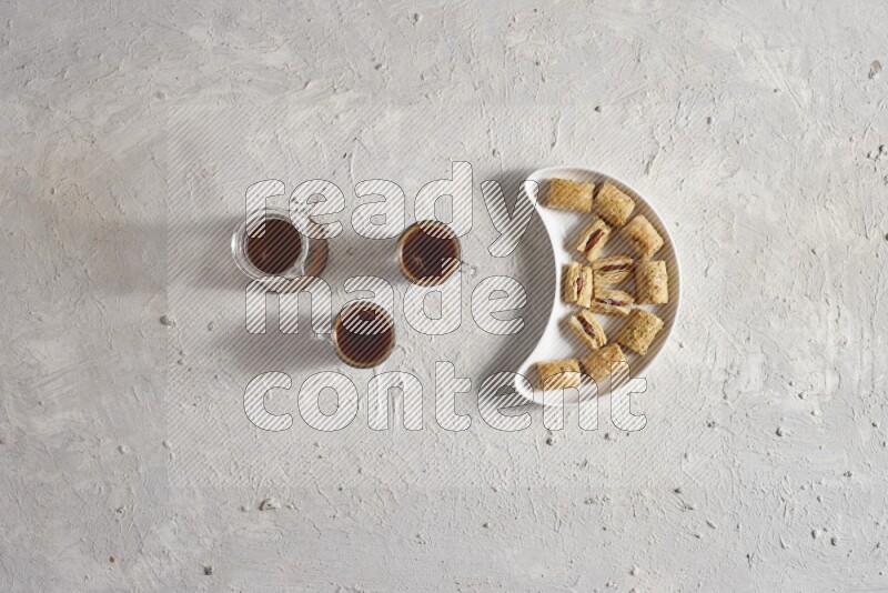 Oriental sweets in a pottery plate with drinks in a light setup