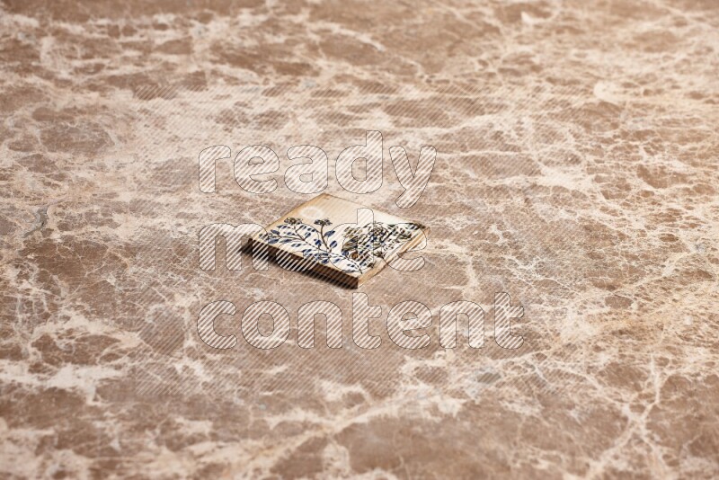 A decorative coaster on beige marble background