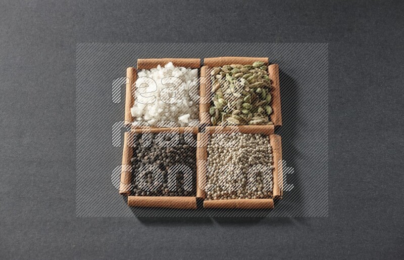 4 squares of cinnamon sticks full of black pepper, white pepper, cardamom and white salt on black flooring