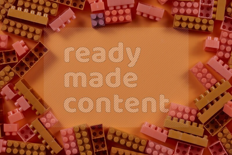 Orange plastic building blocks on orange background (kids toys)