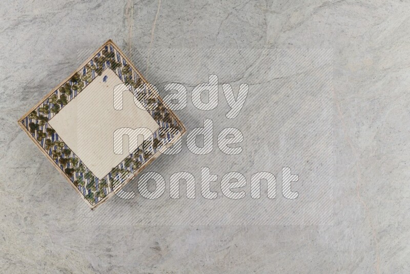 A decorative pottery plate on grey marble background