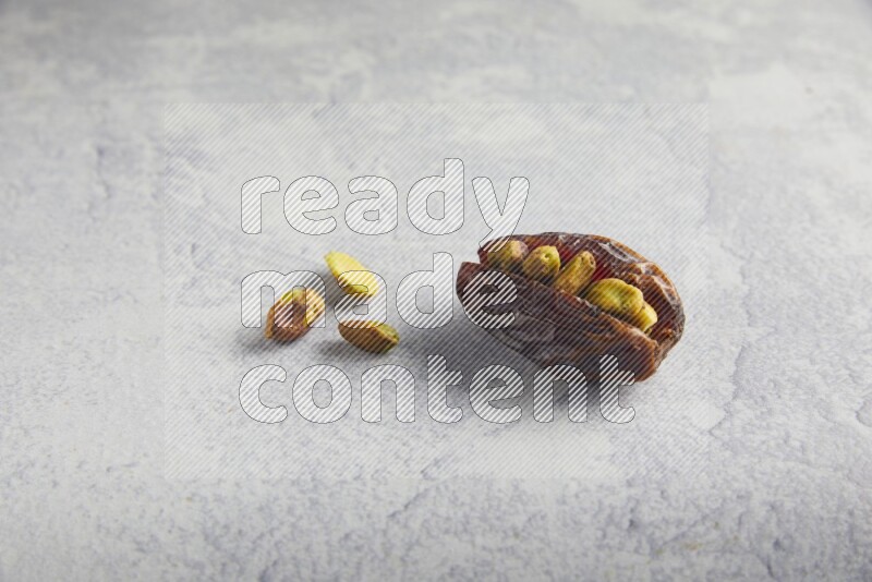 pistachio stuffed madjoul date on a light grey background