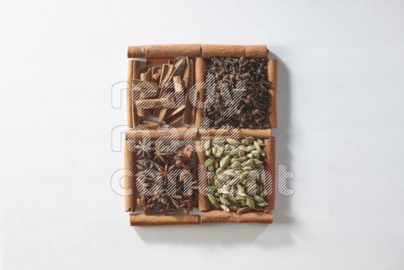 4 squares of cinnamon sticks full of cardamom, star anise, cloves and cinnamon on white flooring