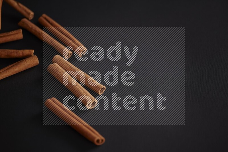 Cinnamon sticks stacked on black flooring