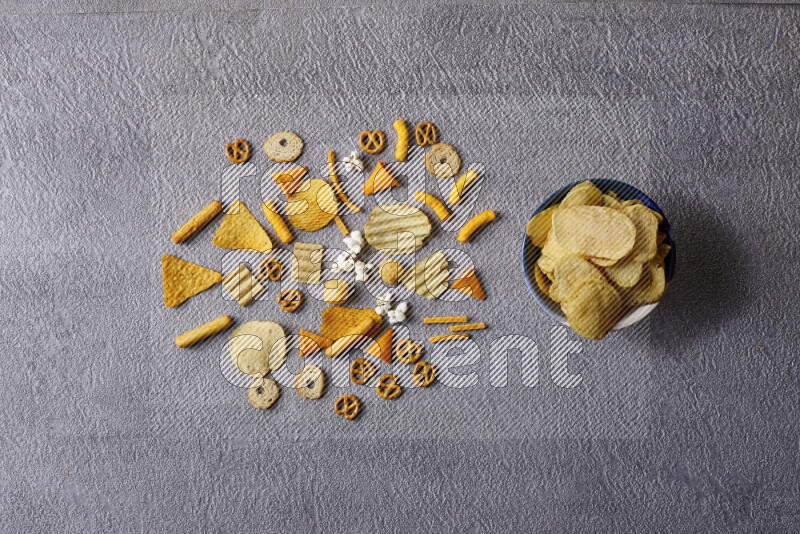 Assorted snacks in pottery bowls on grey background